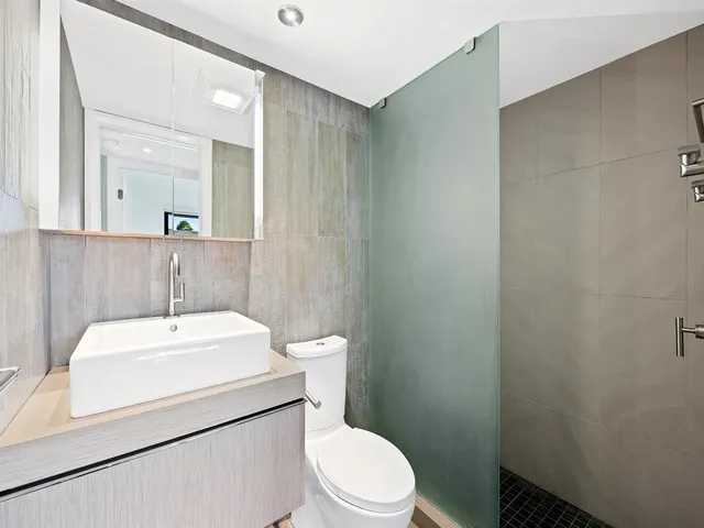 a bathroom with a sink a toilet and mirror