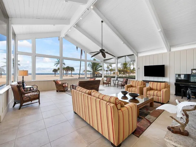 a living room with patio furniture and a flat screen tv