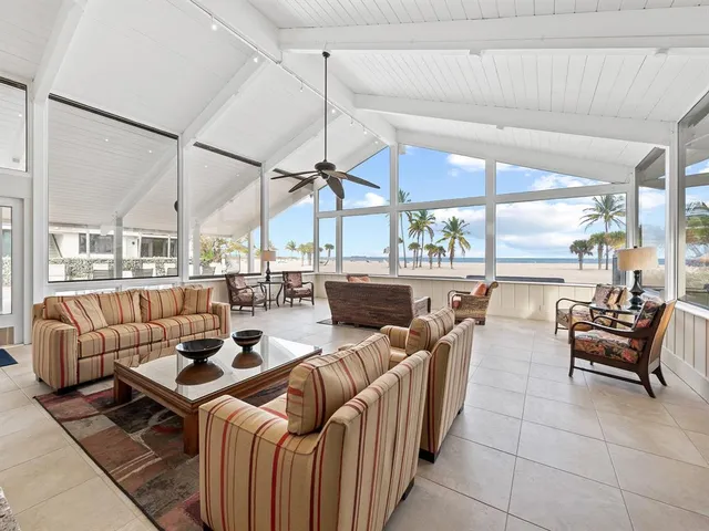 a living room with furniture a large window and chandelier
