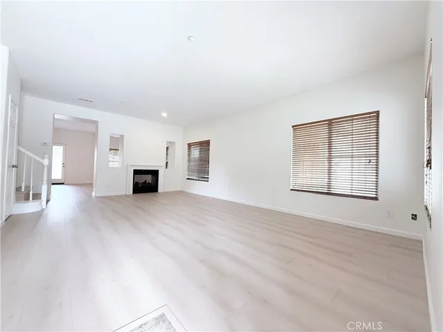 a view of empty room with wooden floor and window