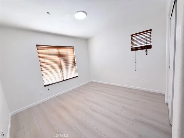 an empty room with windows and cabinet