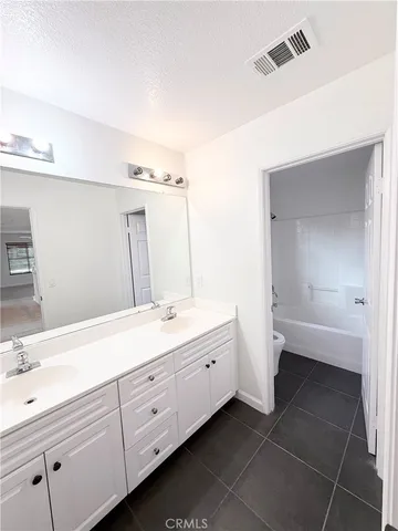 a spacious bathroom with a double vanity sink a mirror and a bathtub