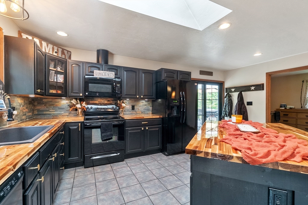 124 Wood Hill Road Monson, MA 01057 - Photo 13 of 41 a kitchen with stainless steel appliances kitchen island granite countertop a sink stove and refrigerator