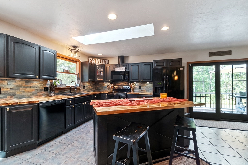 124 Wood Hill Road Monson, MA 01057 - Photo 14 of 41 a kitchen with stainless steel appliances kitchen island granite countertop a sink and cabinets