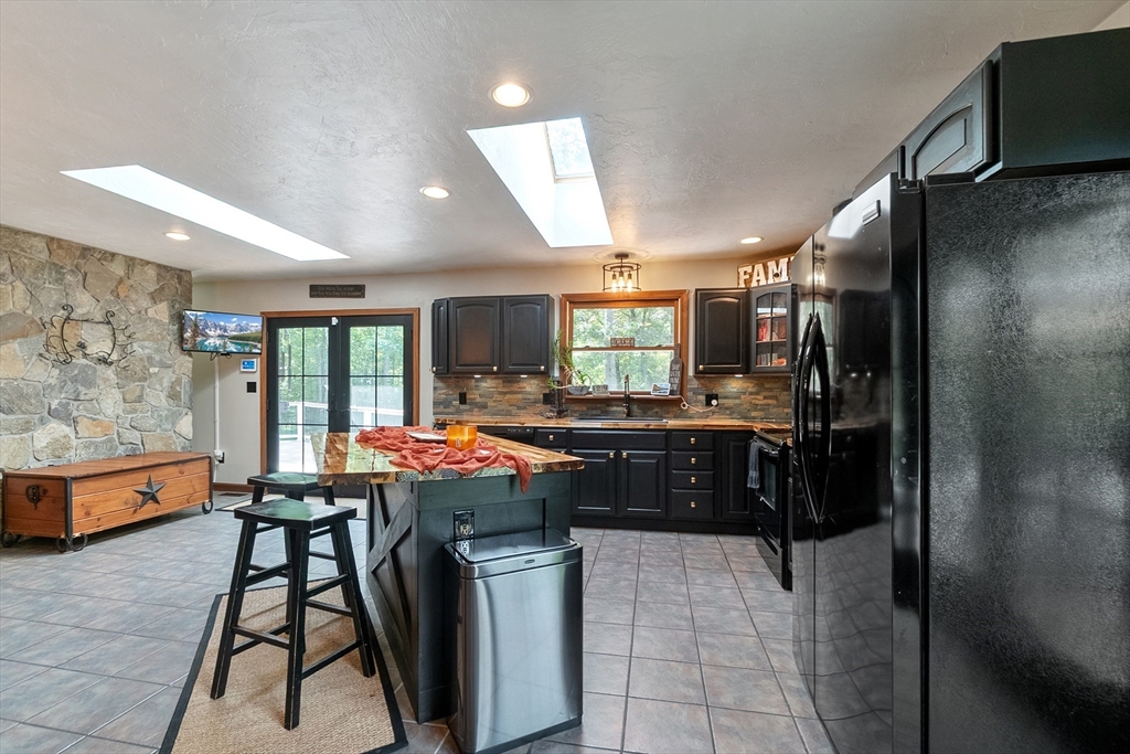 124 Wood Hill Road Monson, MA 01057 - Photo 15 of 41 a kitchen with stainless steel appliances granite countertop a refrigerator a sink a stove and white cabinets