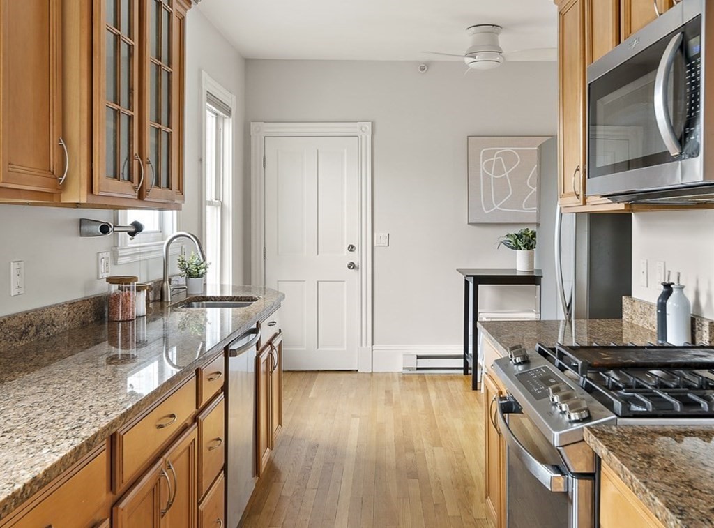 50 Beacon Street, Unit 3 Somerville, MA 02143 - Photo 8 of 15 a kitchen with granite countertop a sink a stove and cabinets