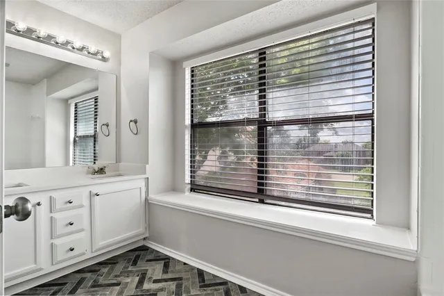 a bathroom with a window sink and a mirror