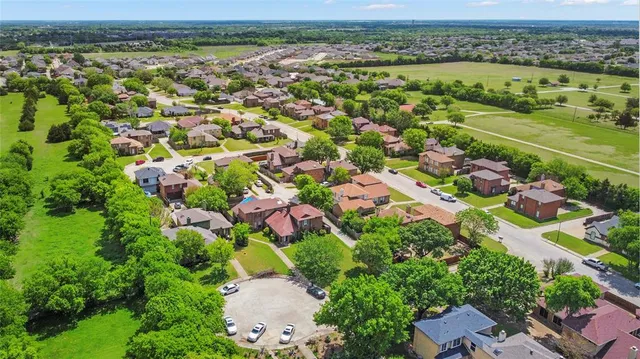 an aerial view of residential houses with outdoor space and trees