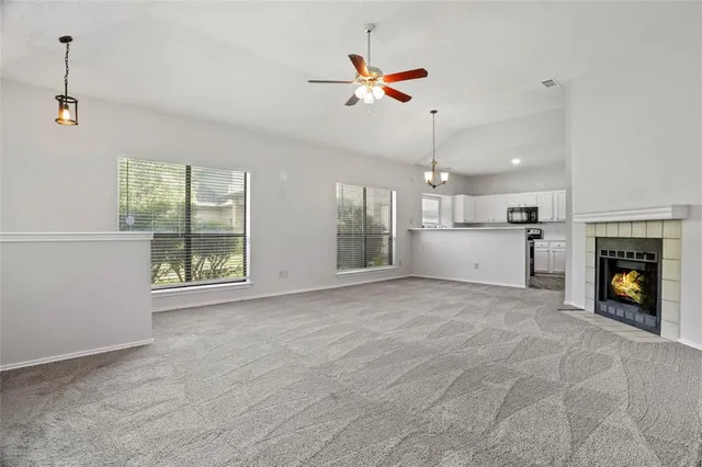 an empty room with windows and fireplace