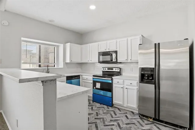 a kitchen with stainless steel appliances granite countertop a refrigerator sink and stove