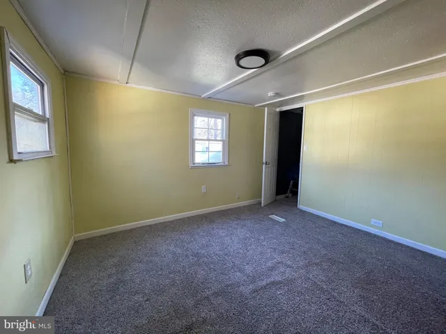 an empty room with windows and closet
