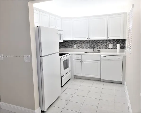 a white refrigerator freezer sitting inside of a kitchen