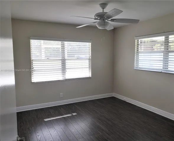 a view of a room with wooden floor and windows