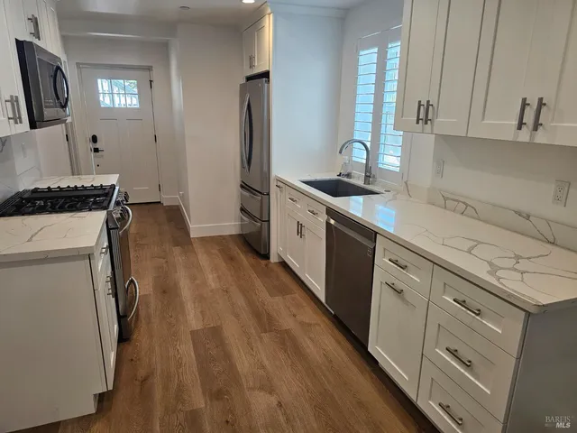 a kitchen with cabinets a sink and appliances
