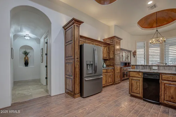 a kitchen with stainless steel appliances granite countertop a refrigerator a stove and a sink