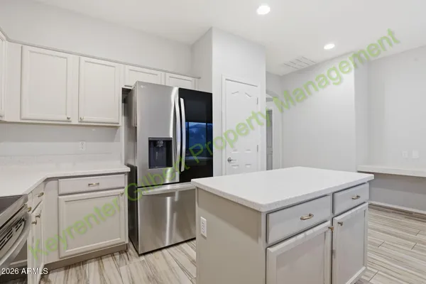 a kitchen with a sink a refrigerator a microwave and cabinets