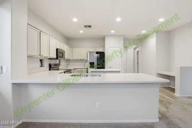 a kitchen with white cabinets and white appliances