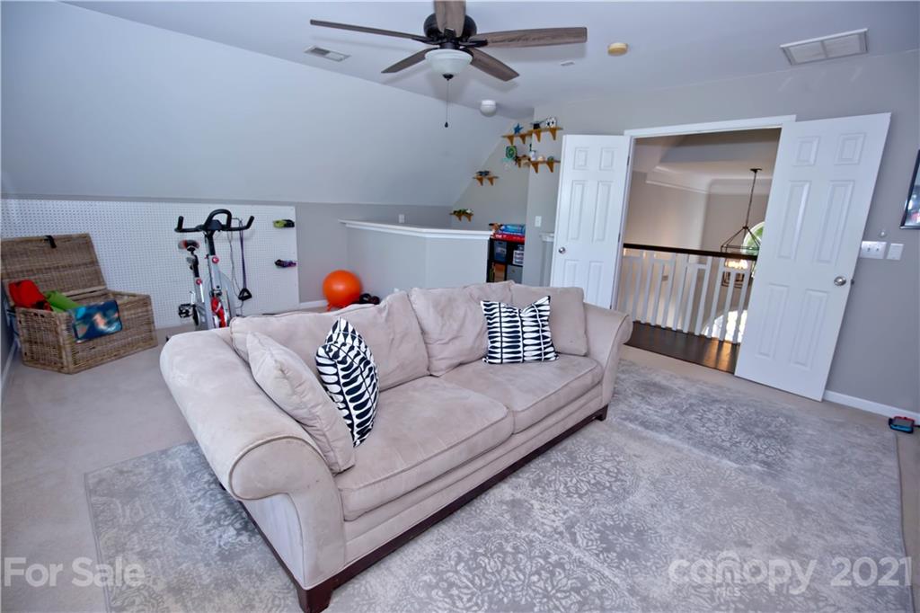 20200 Tailwind Lane Cornelius, NC 28031 - Photo 23 of 28 a living room with furniture and a chandelier