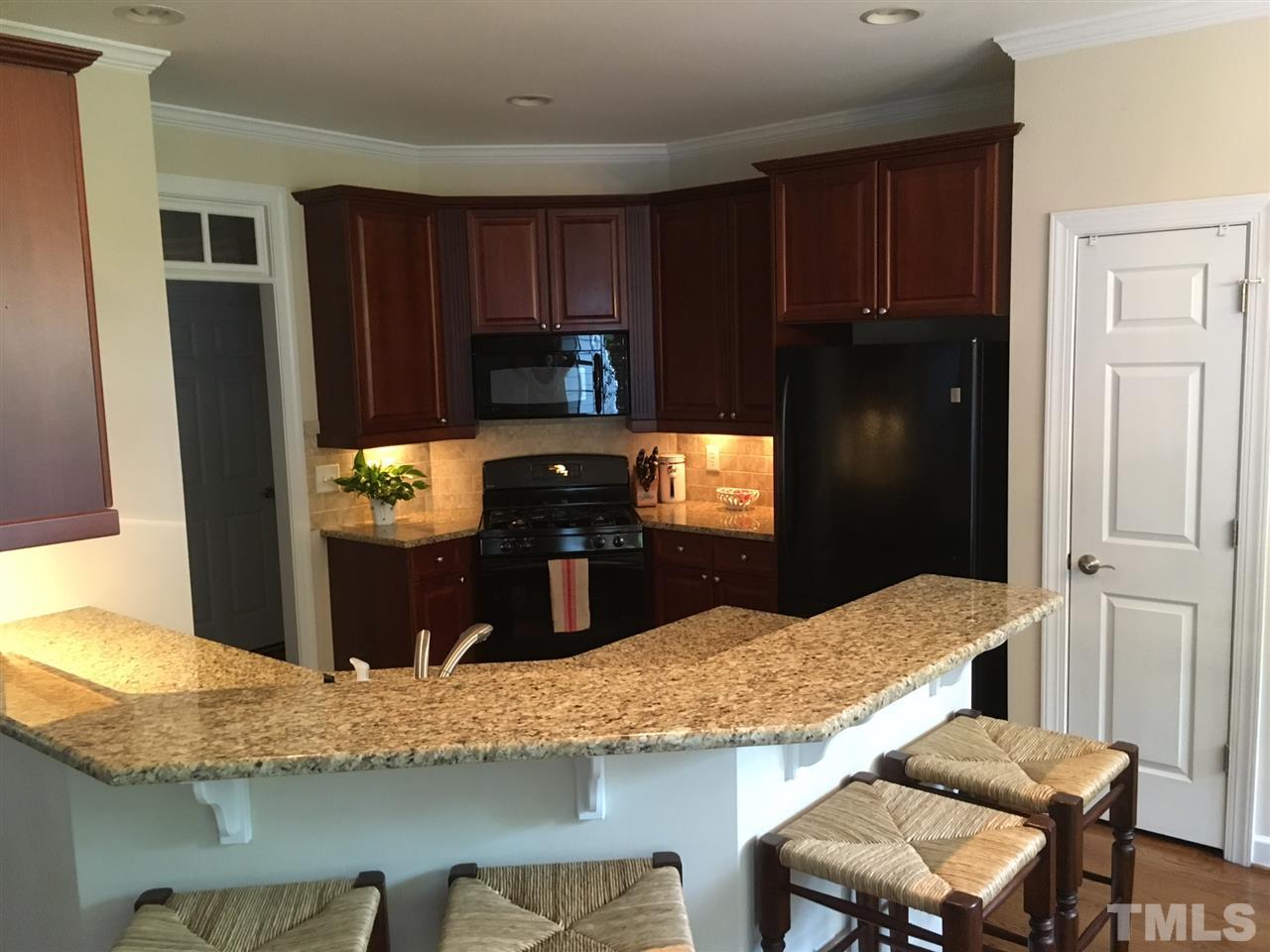 1618 Weatherford Circle Raleigh, NC 27604 - Photo 9 of 20 a kitchen with granite countertop wooden cabinets and refrigerator