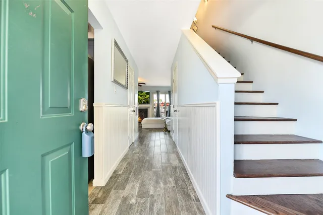 a view of a hallway with wooden floor and staircase