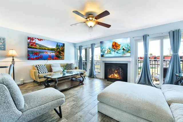 a living room with furniture a fireplace and a large window