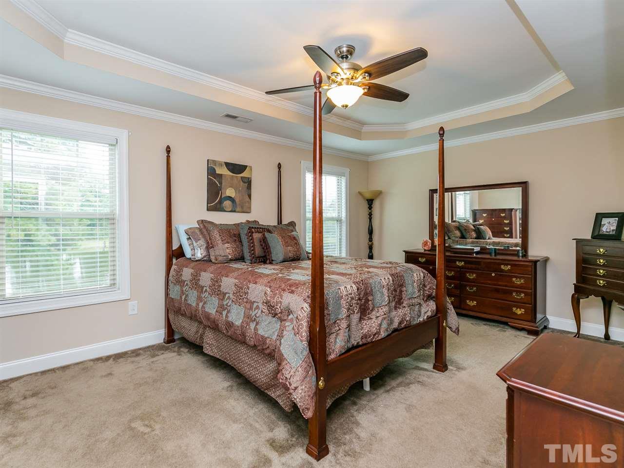 7726 Cedarshire Court Raleigh, NC 27616 - Photo 18 of 28 a bedroom with a bed and a chandelier