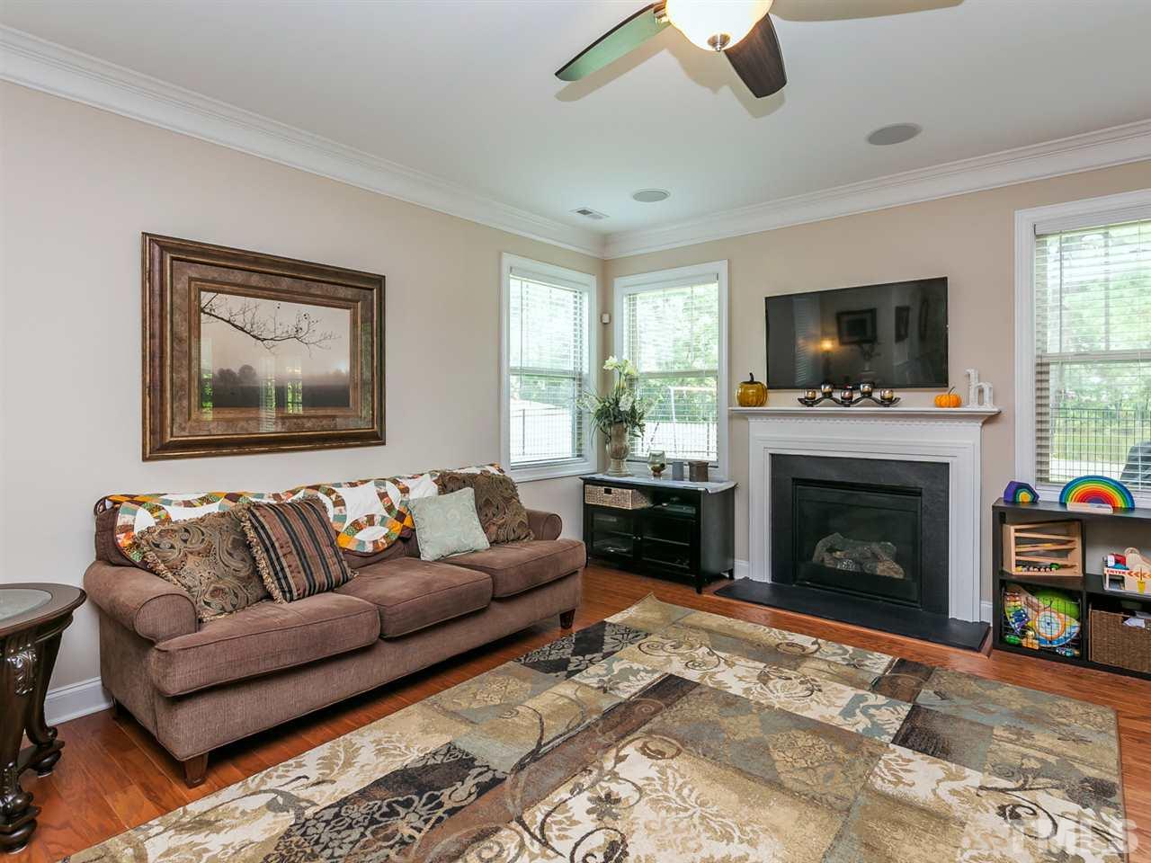 7726 Cedarshire Court Raleigh, NC 27616 - Photo 4 of 28 a living room with furniture a flat screen tv and a fireplace