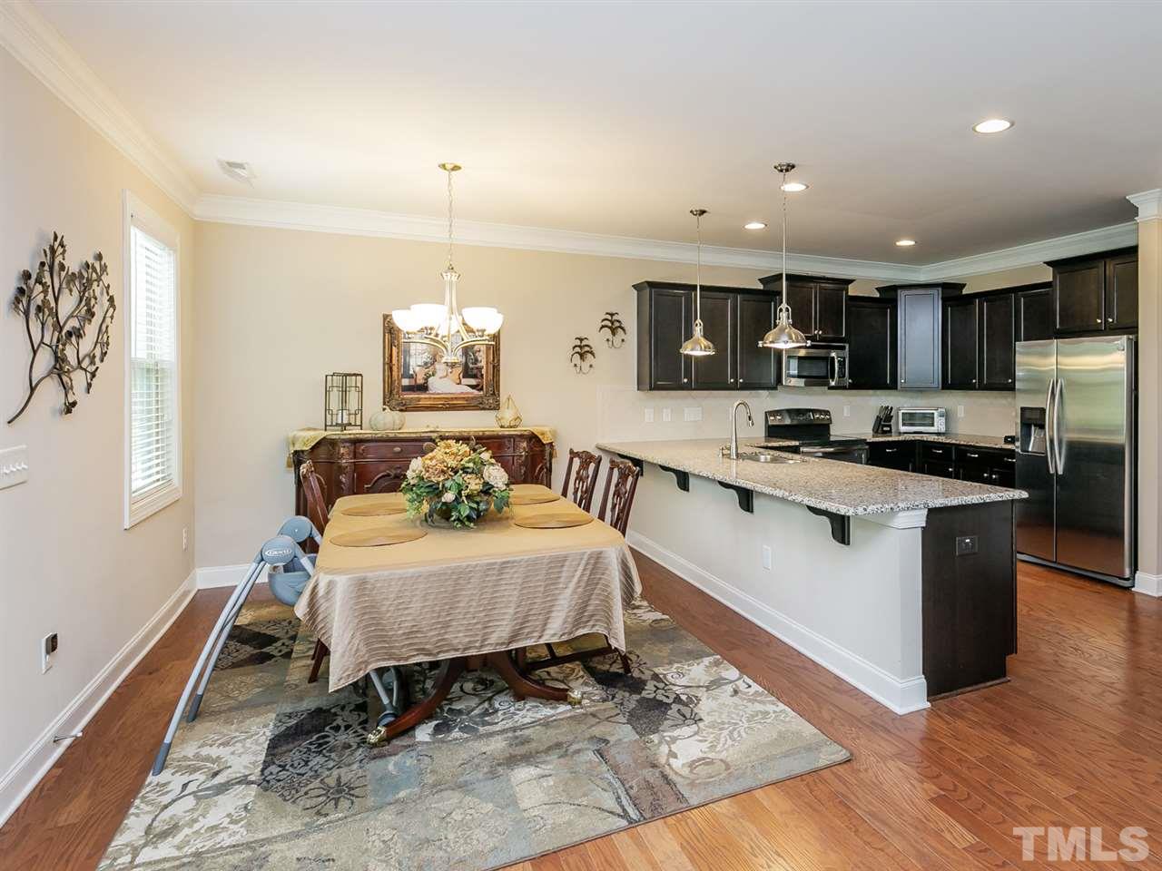 7726 Cedarshire Court Raleigh, NC 27616 - Photo 6 of 28 a spacious bedroom with a bed a table in it and wooden floors