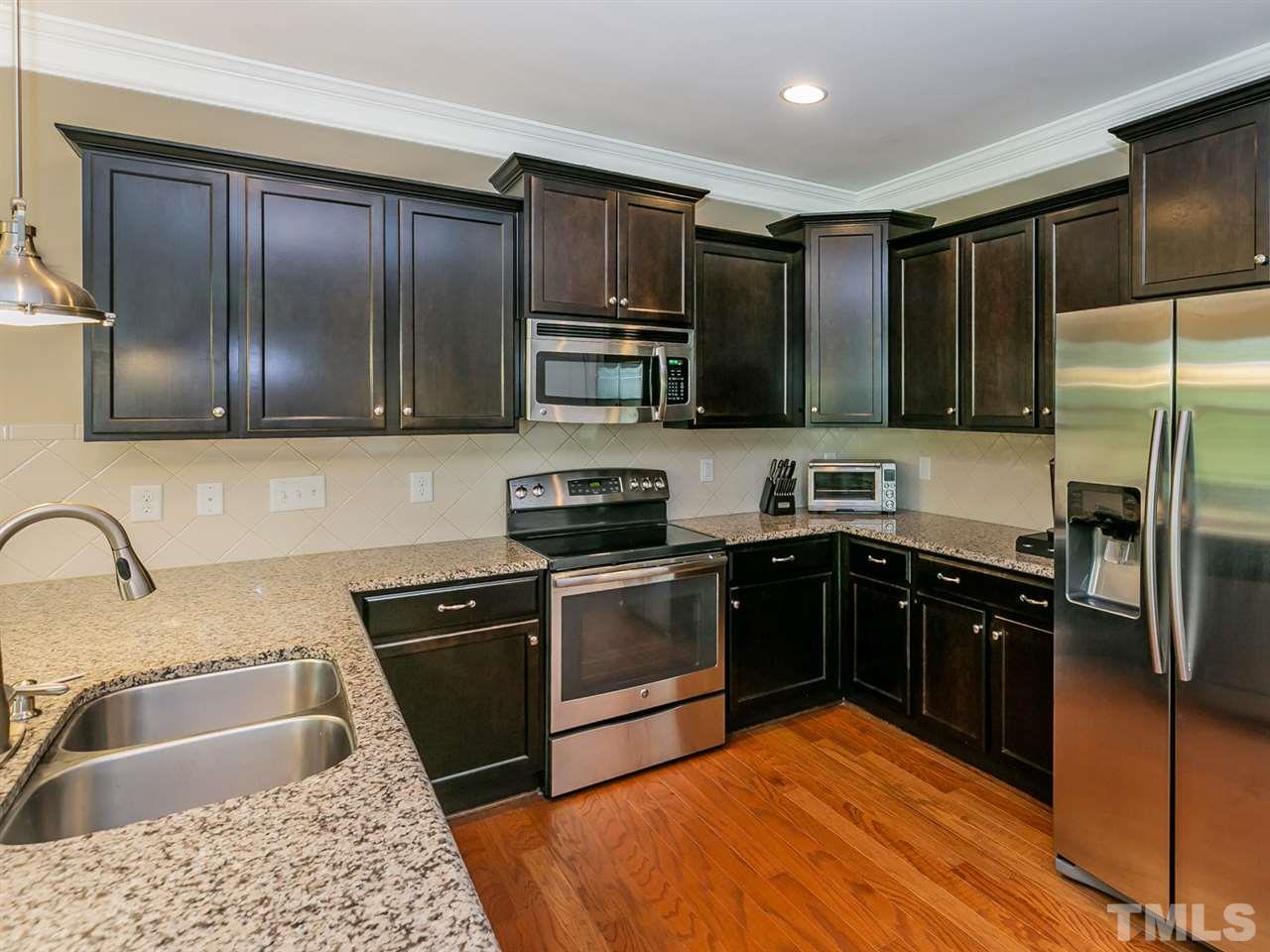 7726 Cedarshire Court Raleigh, NC 27616 - Photo 8 of 28 a kitchen with granite countertop stainless steel appliances and wooden cabinets