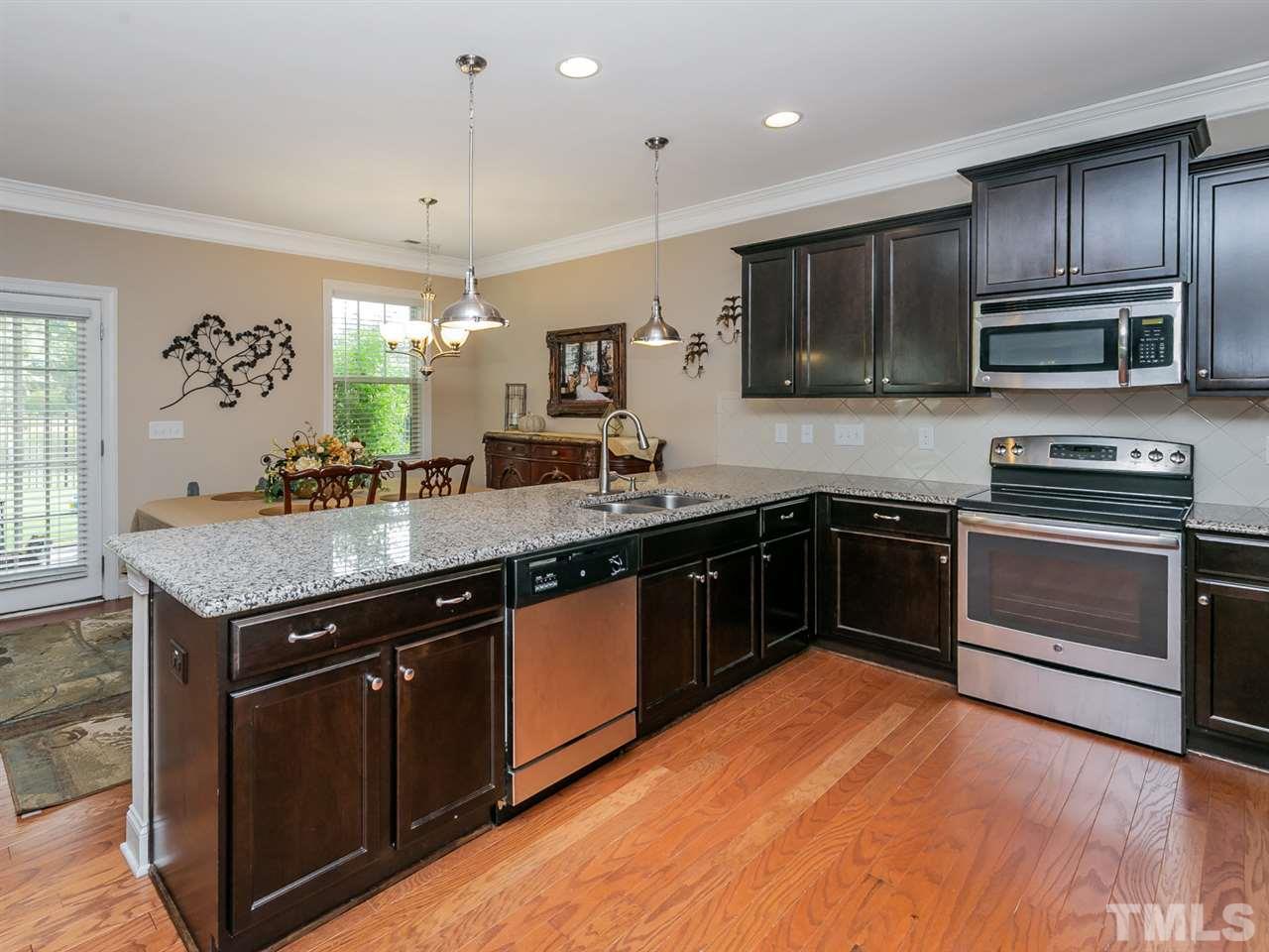 7726 Cedarshire Court Raleigh, NC 27616 - Photo 9 of 28 a kitchen with granite countertop stainless steel appliances and wooden cabinets