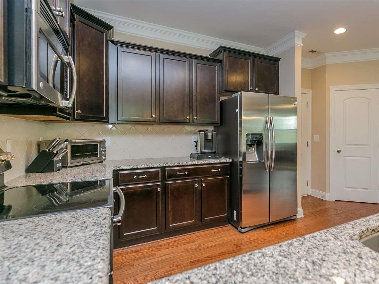 7726 Cedarshire Court Raleigh, NC 27616 - Photo 10 of 28 a kitchen with granite countertop stainless steel appliances and wooden cabinets