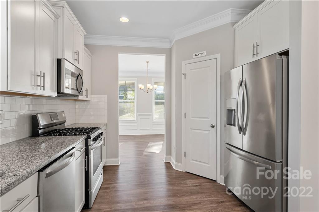 4025 Shadowbrook Road Waxhaw, NC 28173 - Photo 12 of 48 a kitchen with stainless steel appliances granite countertop a refrigerator a stove and a sink with granite countertops