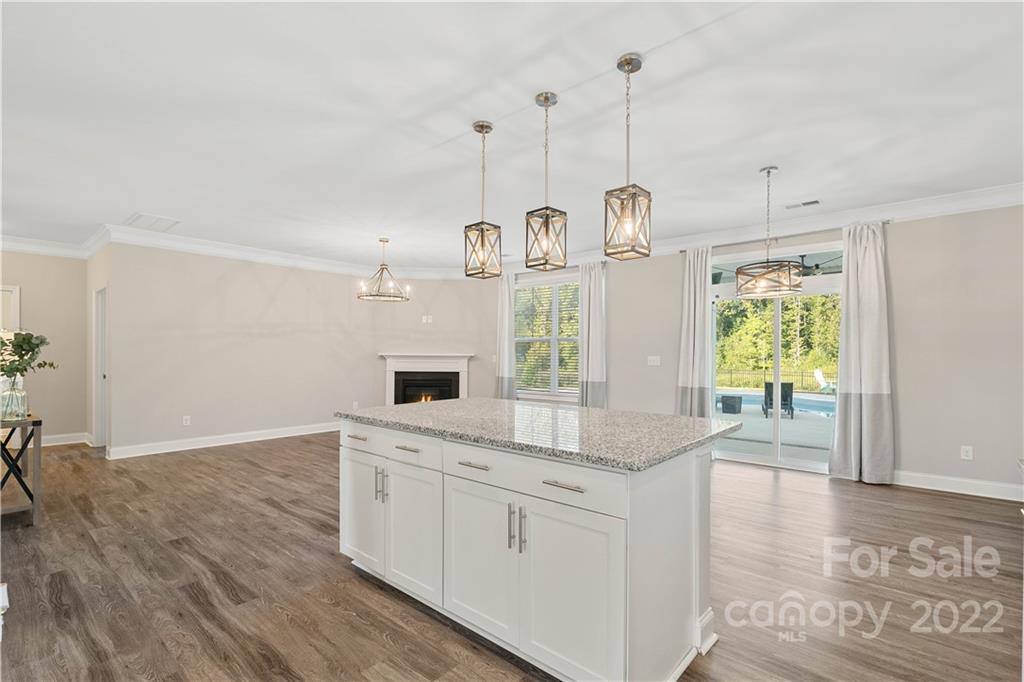 4025 Shadowbrook Road Waxhaw, NC 28173 - Photo 13 of 48 a kitchen with kitchen island a stove a sink a center island a refrigerator and a wooden floor