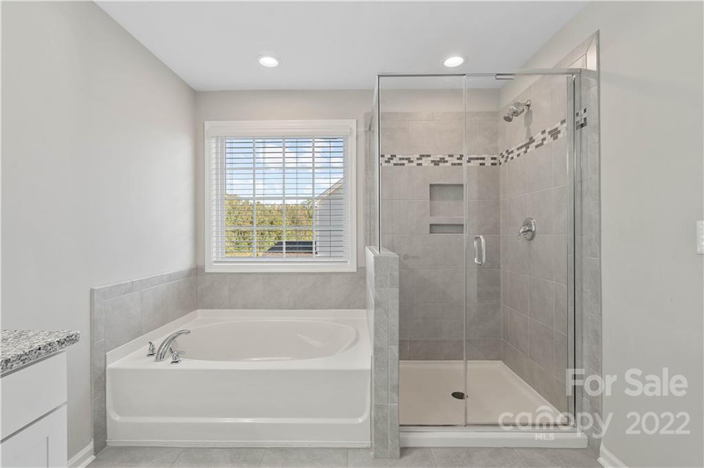 4025 Shadowbrook Road Waxhaw, NC 28173 - Photo 35 of 48 a bathroom with a bathtub a shower and a window