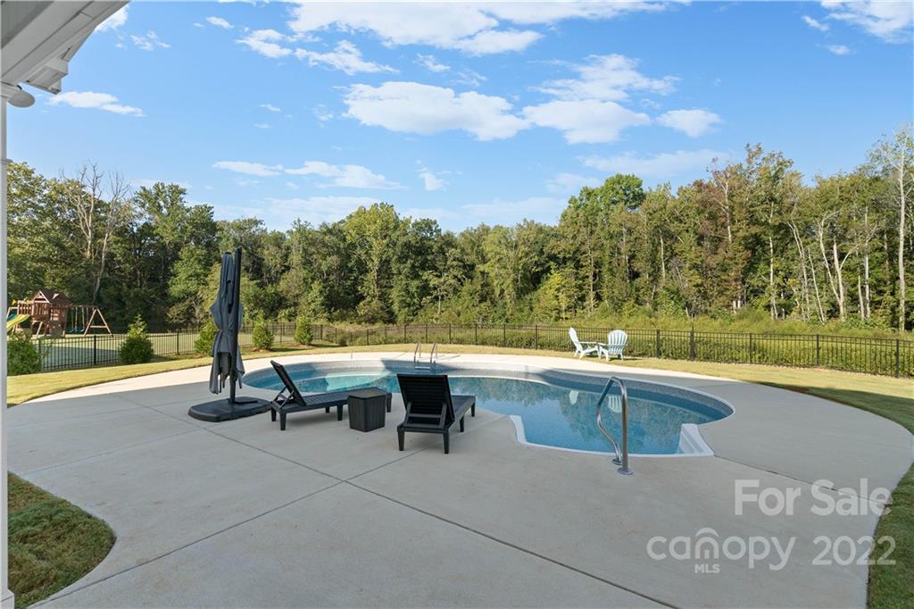 4025 Shadowbrook Road Waxhaw, NC 28173 - Photo 38 of 48 a view of swimming pool with outdoor seating and trees in the background