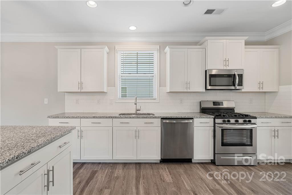 4025 Shadowbrook Road Waxhaw, NC 28173 - Photo 9 of 48 a kitchen with stainless steel appliances granite countertop a stove a sink and a microwave