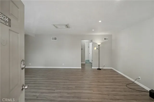 a view of empty room with wooden floor