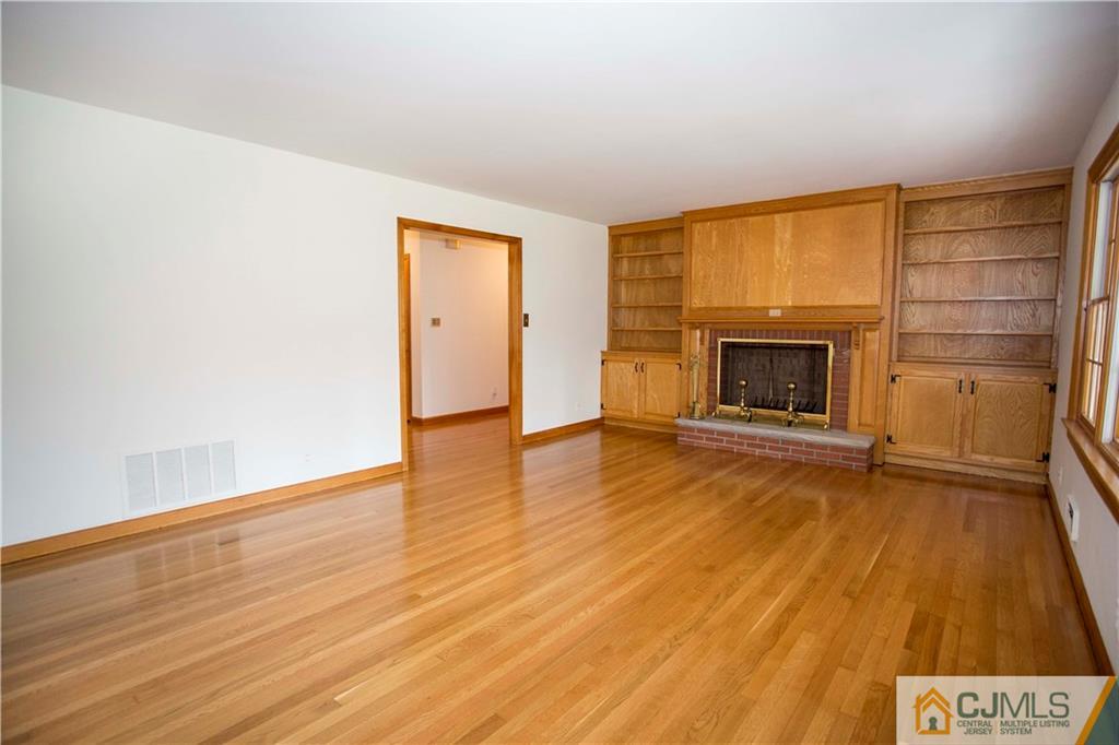 103 Buchanan Road Edison, NJ 08820 - Photo 11 of 25 a view of empty room with wooden floor and fireplace