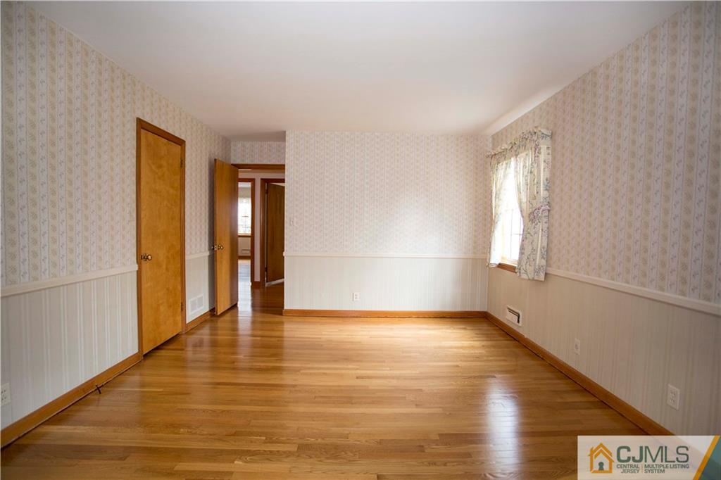 103 Buchanan Road Edison, NJ 08820 - Photo 14 of 25 a view of an empty room with wooden floor and a window