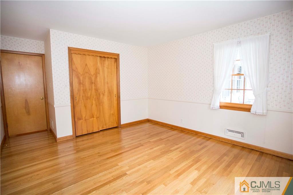 103 Buchanan Road Edison, NJ 08820 - Photo 16 of 25 a view of an empty room with wooden floor and a window