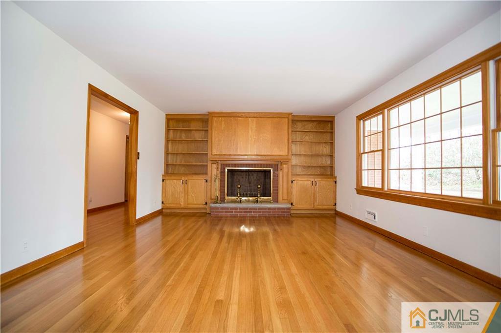 103 Buchanan Road Edison, NJ 08820 - Photo 9 of 25 wooden floor fireplace and windows in an empty room