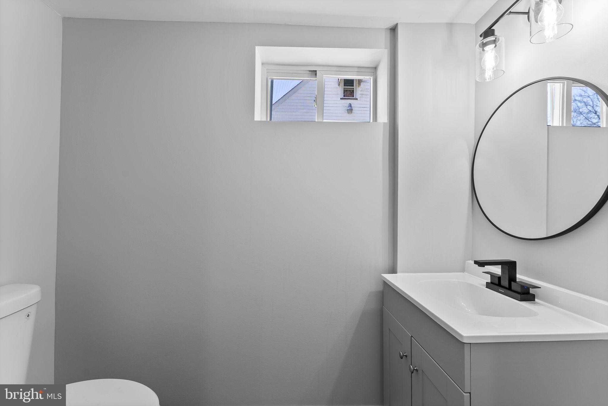 8310 Karl Avenue Rosedale, MD 21237 - Photo 31 of 39 a bathroom with a toilet a sink and mirror