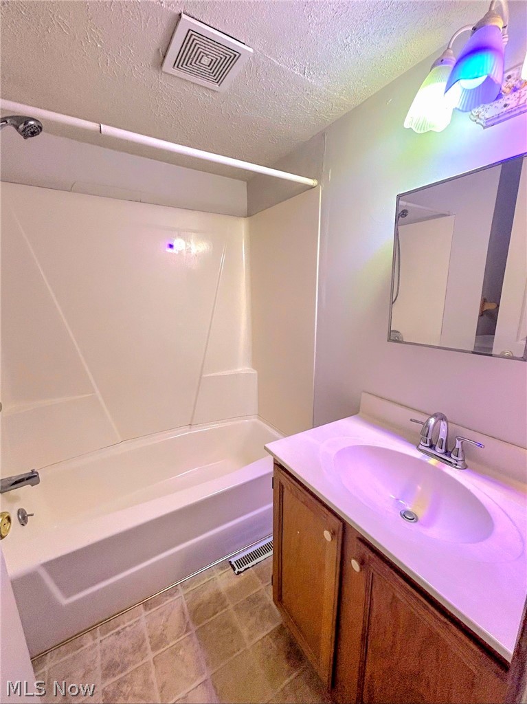4722 Warren - Sharon Road Vienna, OH 44473 - Photo 7 of 8 Bathroom featuring shower / bath combination, tile floors, oversized vanity, and a textured ceiling