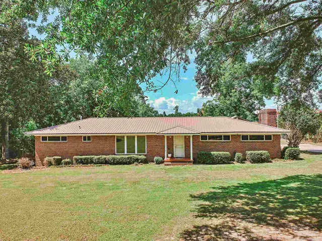 a front view of a house with a yard table and chairs