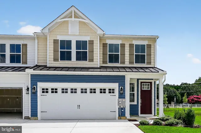 a front view of a building with glass windows and yard