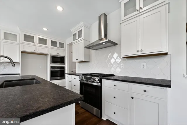 a kitchen with stainless steel appliances granite countertop a sink and stove