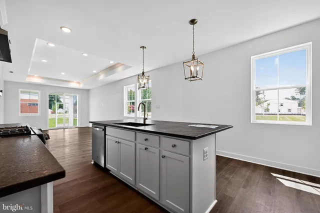 a kitchen with sink stove and wooden floor