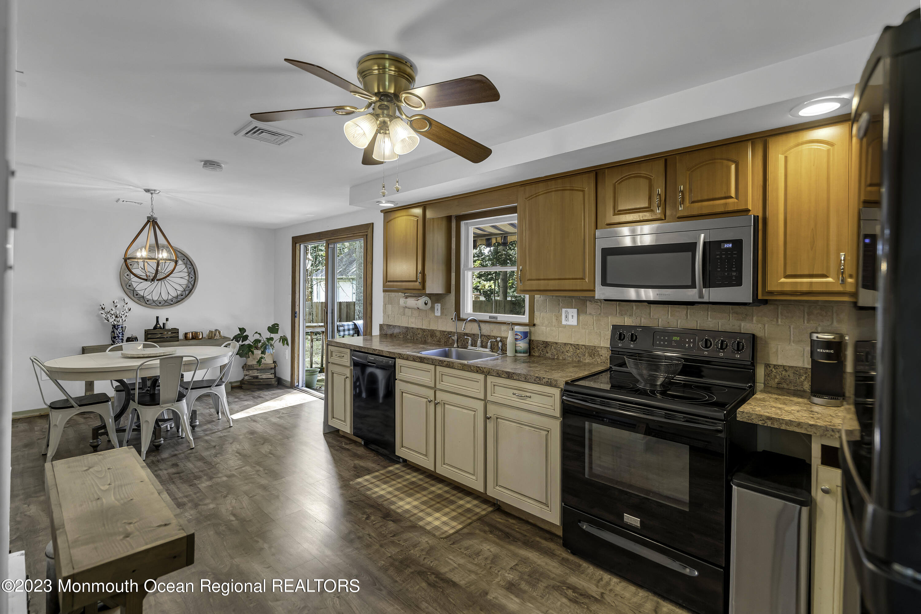 26 Frank Applegate Road Jackson, NJ 08527 - Photo 7 of 16 a kitchen with stainless steel appliances granite countertop a stove top oven a sink a dining table and chairs with wooden floor