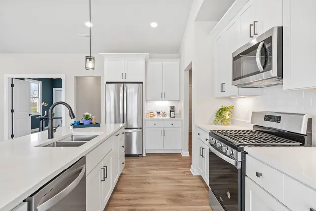 a kitchen with stainless steel appliances a sink stove and refrigerator