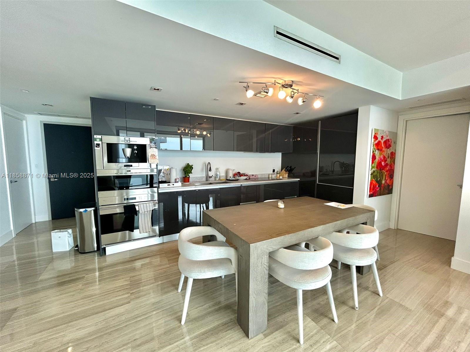 1451 Brickell Avenue, Unit 2102 Miami, FL 33131 - Photo 6 of 14 a kitchen with a table and chairs in it